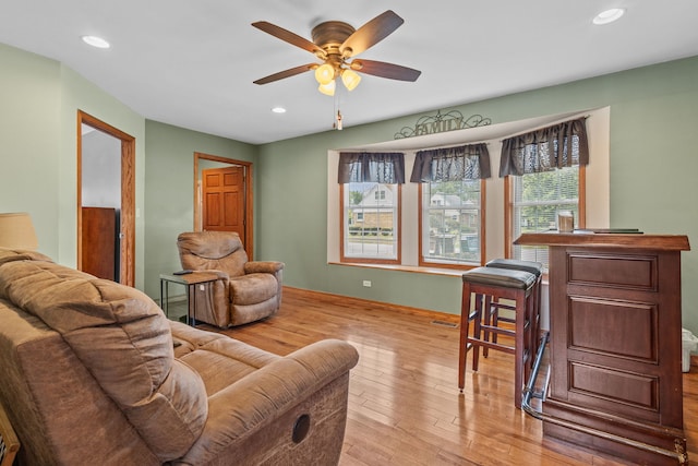 living room with ceiling fan and light hardwood / wood-style flooring