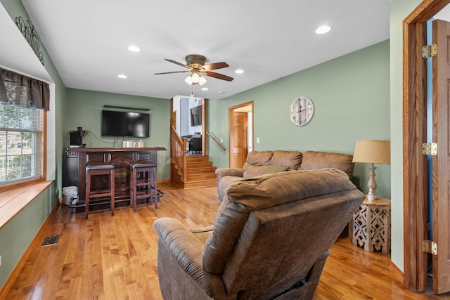 living room with ceiling fan and light hardwood / wood-style flooring