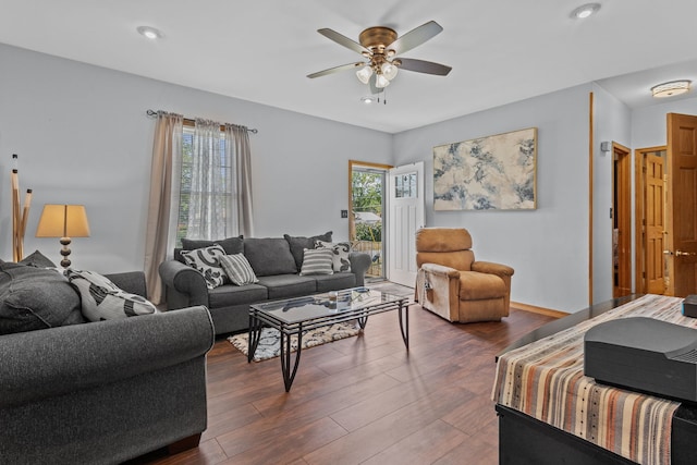 living room with ceiling fan, dark wood-type flooring, and a wealth of natural light