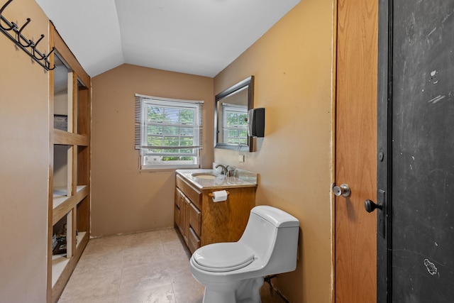 bathroom featuring vanity, toilet, and vaulted ceiling