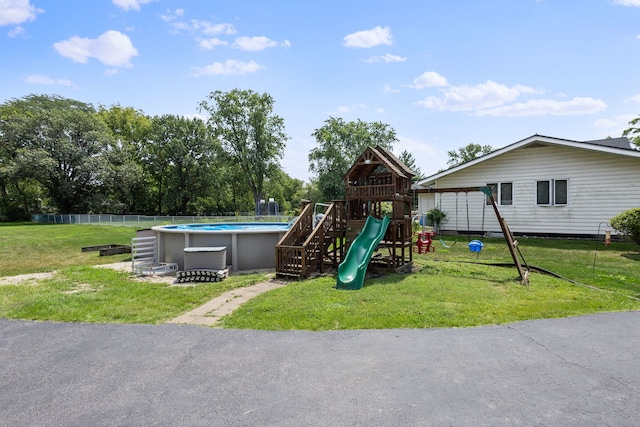 view of jungle gym with a yard and a fenced in pool