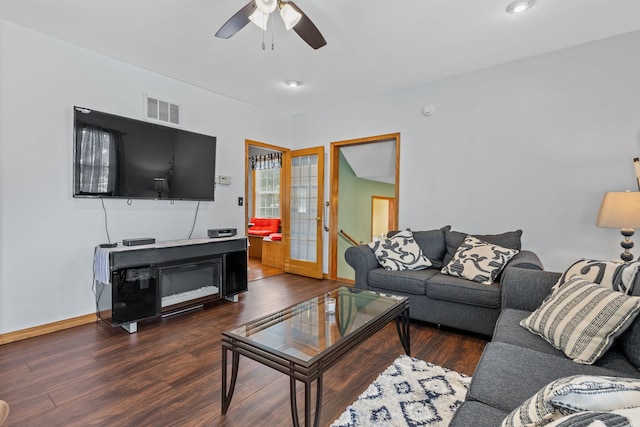 living room featuring ceiling fan and dark wood-type flooring