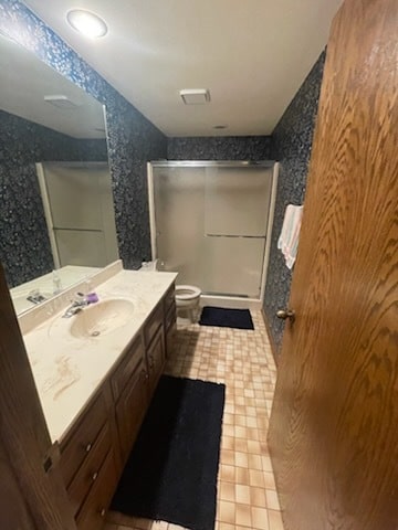 bathroom with vanity, toilet, and walk in shower