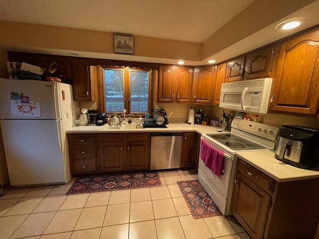 kitchen with white appliances, sink, and light tile patterned floors