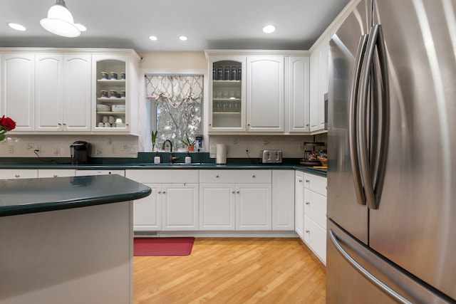 kitchen with white cabinets, stainless steel fridge, and light hardwood / wood-style floors