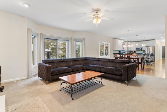 carpeted living room featuring ceiling fan