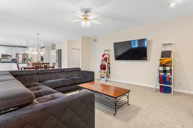 carpeted living room with ceiling fan