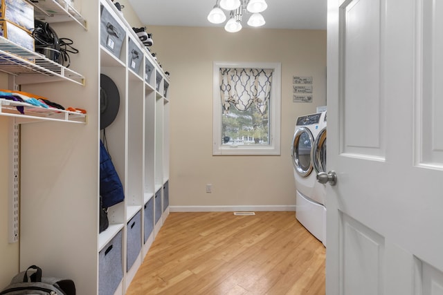 laundry room with washer / clothes dryer, a notable chandelier, and hardwood / wood-style flooring