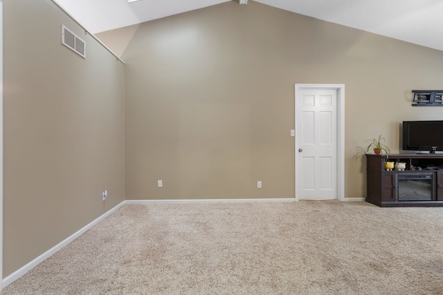 unfurnished living room with vaulted ceiling with skylight and carpet flooring