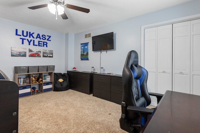 carpeted office space featuring ceiling fan