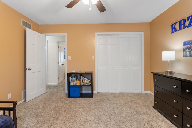 carpeted bedroom featuring a closet and ceiling fan