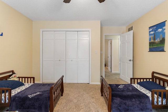 bedroom with ceiling fan, a closet, and light carpet