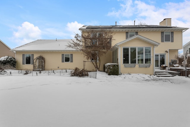 view of snow covered back of property