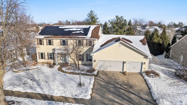 colonial house featuring solar panels and a garage