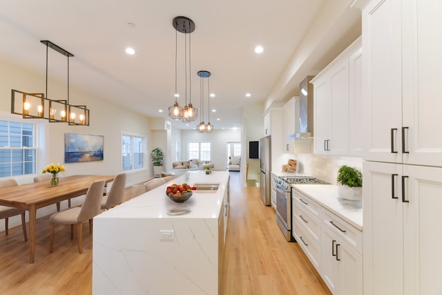 kitchen with white cabinetry, stainless steel appliances, and decorative light fixtures