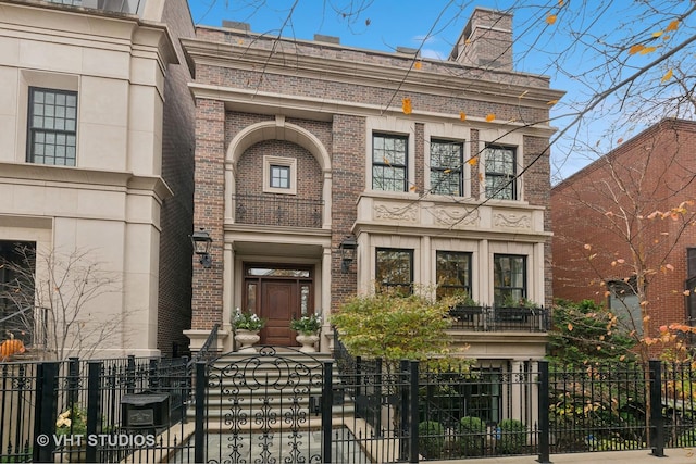 view of front of property featuring brick siding and a fenced front yard