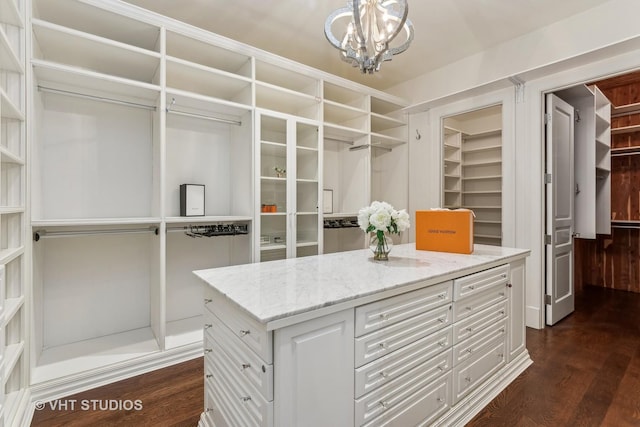 spacious closet featuring a chandelier and dark wood-style flooring