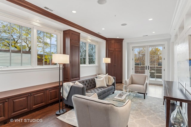 interior space featuring ornamental molding, plenty of natural light, wood finished floors, and visible vents