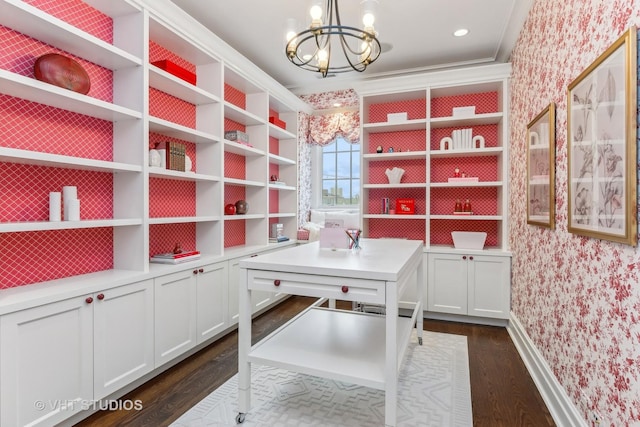 unfurnished office featuring wallpapered walls, baseboards, dark wood-type flooring, and an inviting chandelier