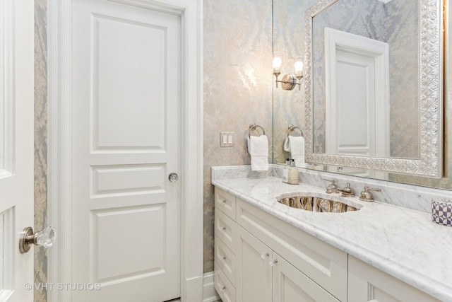 bathroom featuring wallpapered walls and vanity