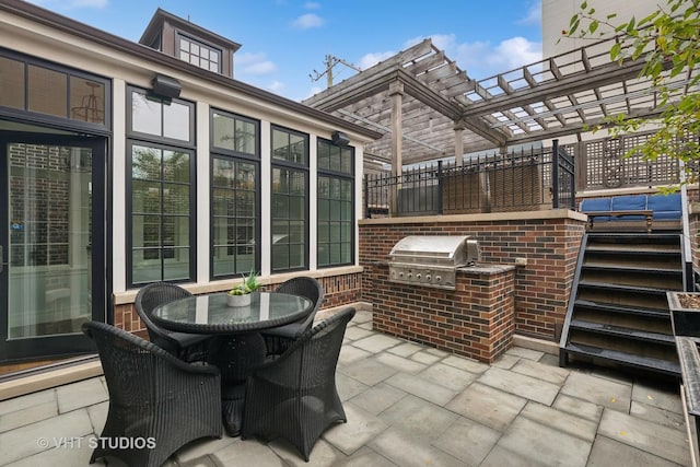 view of patio / terrace with outdoor dining space, an outdoor kitchen, and a grill