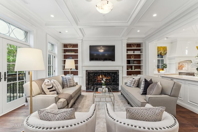 living room with built in shelves, a premium fireplace, coffered ceiling, and beam ceiling