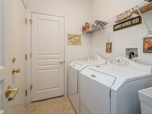 washroom with sink, light tile patterned floors, and independent washer and dryer