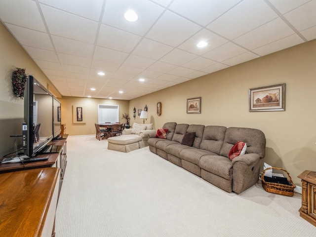 carpeted living room featuring a drop ceiling