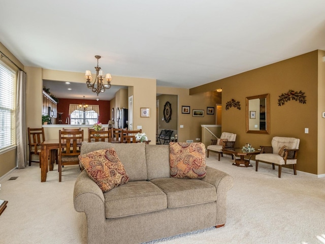 carpeted living room featuring an inviting chandelier