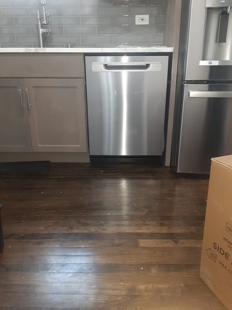 kitchen featuring appliances with stainless steel finishes, backsplash, sink, dark hardwood / wood-style floors, and white cabinetry