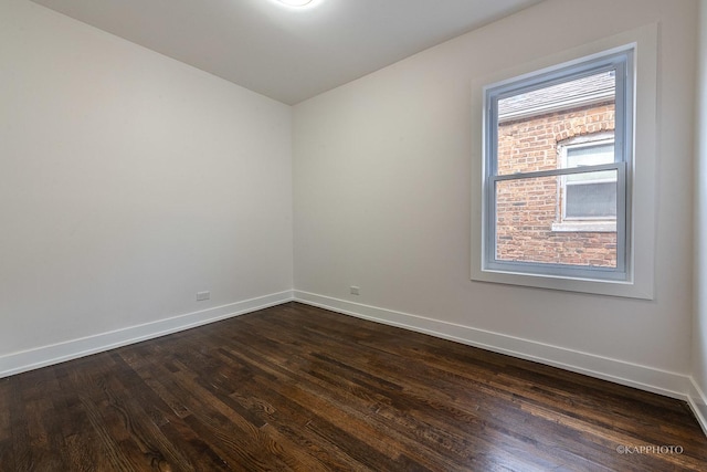 unfurnished room with dark wood-type flooring