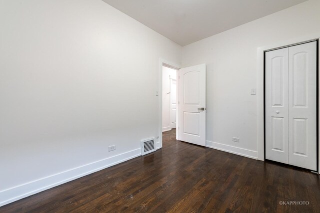 unfurnished bedroom featuring dark hardwood / wood-style floors and a closet