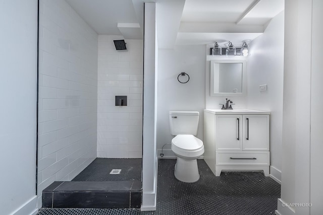 bathroom featuring a tile shower, tile patterned flooring, vanity, and toilet