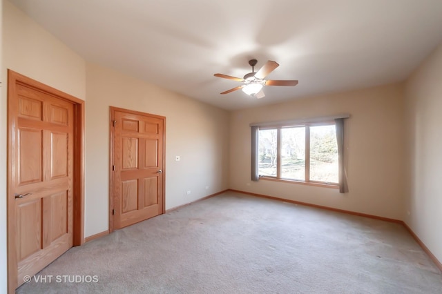 carpeted spare room with ceiling fan