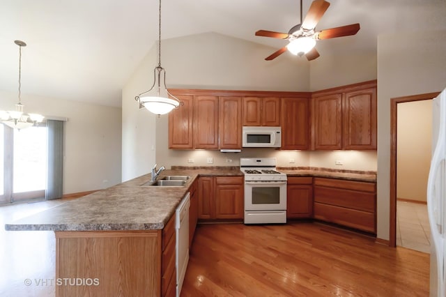 kitchen with hardwood / wood-style floors, hanging light fixtures, white appliances, and sink