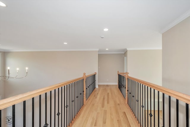 hallway with a chandelier, crown molding, and light hardwood / wood-style floors