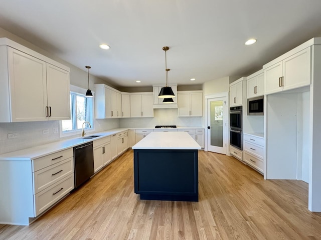 kitchen with light wood-type flooring, a sink, a center island, stainless steel appliances, and decorative backsplash