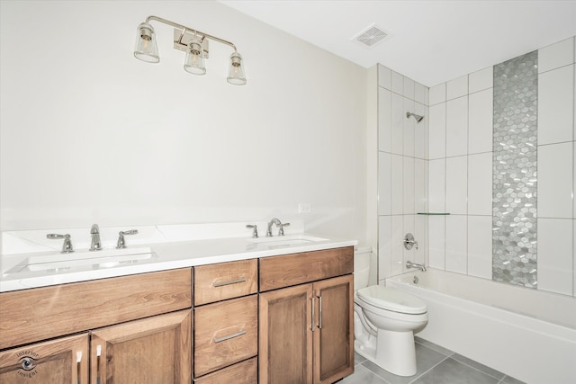 full bathroom with tile patterned flooring, vanity, tiled shower / bath combo, and toilet