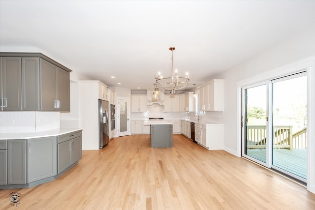 kitchen with gray cabinetry, white cabinets, wall chimney range hood, and appliances with stainless steel finishes