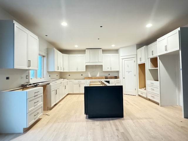 kitchen featuring white cabinets, light wood-type flooring, and a kitchen island