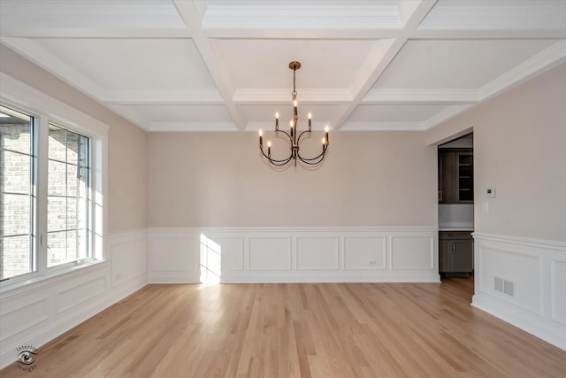 spare room featuring light hardwood / wood-style flooring, a healthy amount of sunlight, and coffered ceiling