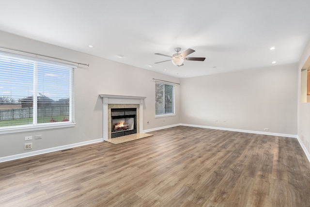 unfurnished living room with wood-type flooring and ceiling fan