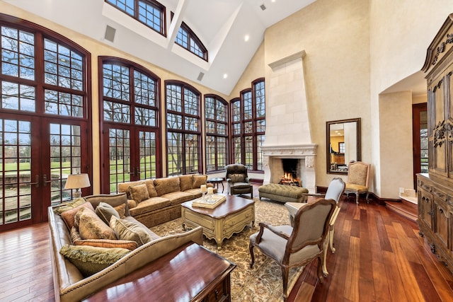 living room with french doors, a large fireplace, dark hardwood / wood-style floors, and high vaulted ceiling