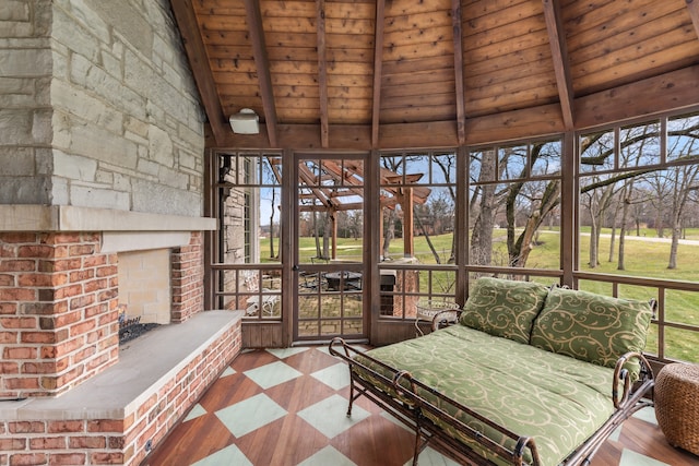 unfurnished sunroom featuring a fireplace, vaulted ceiling with beams, a wealth of natural light, and wooden ceiling