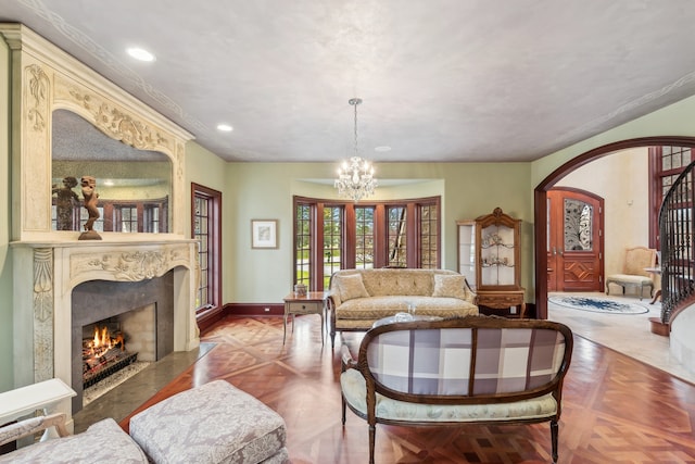 living room with a high end fireplace, parquet floors, and a chandelier