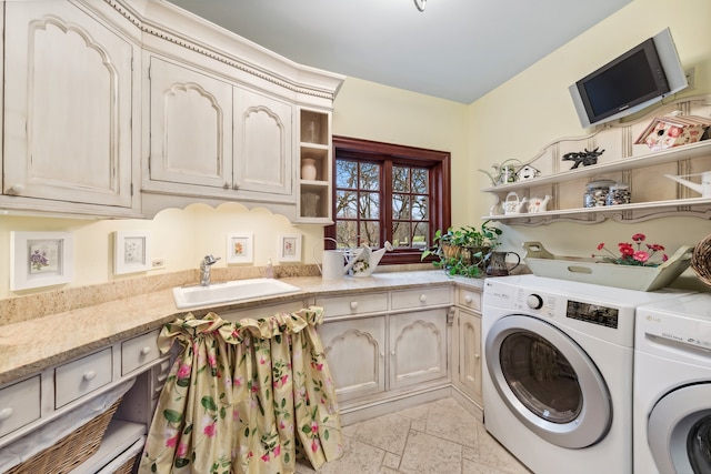 laundry room with cabinets, separate washer and dryer, and sink