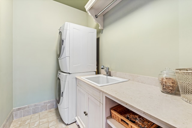 laundry area with sink, light tile patterned flooring, cabinets, and stacked washer / drying machine