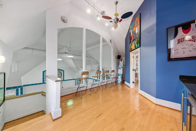 interior space with ceiling fan, lofted ceiling, and hardwood / wood-style flooring