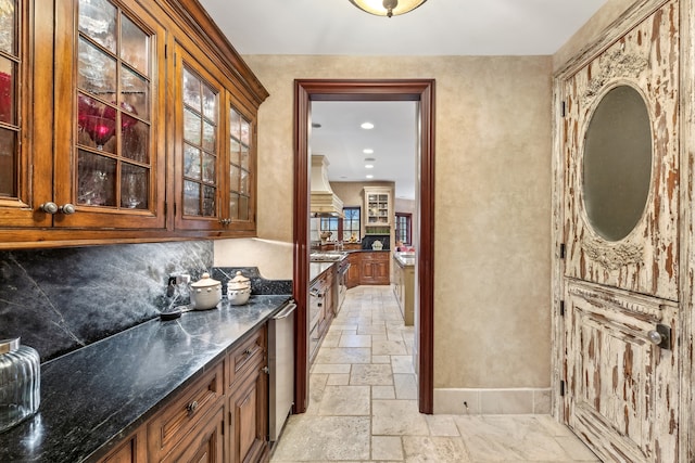 bar with backsplash, premium range hood, and dark stone counters