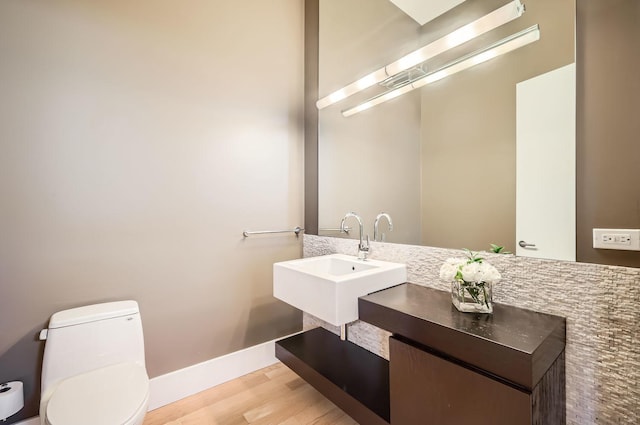 bathroom featuring vanity, toilet, and hardwood / wood-style floors